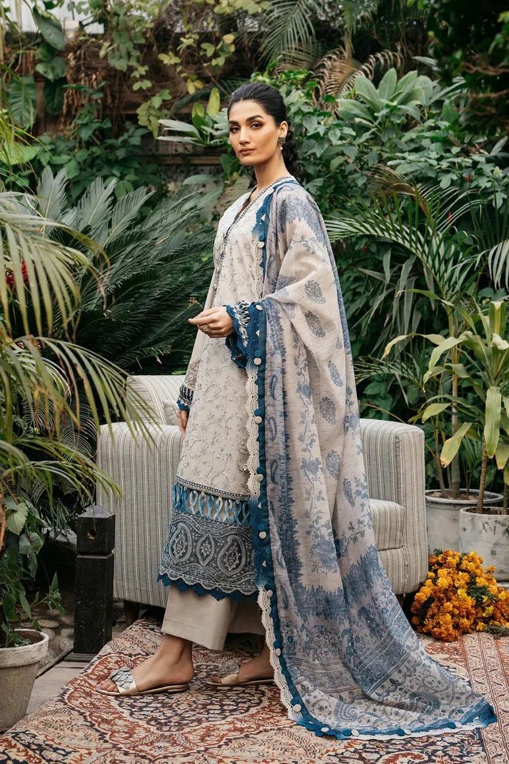 Woman in a traditional outfit standing in a garden with plants and a chair.