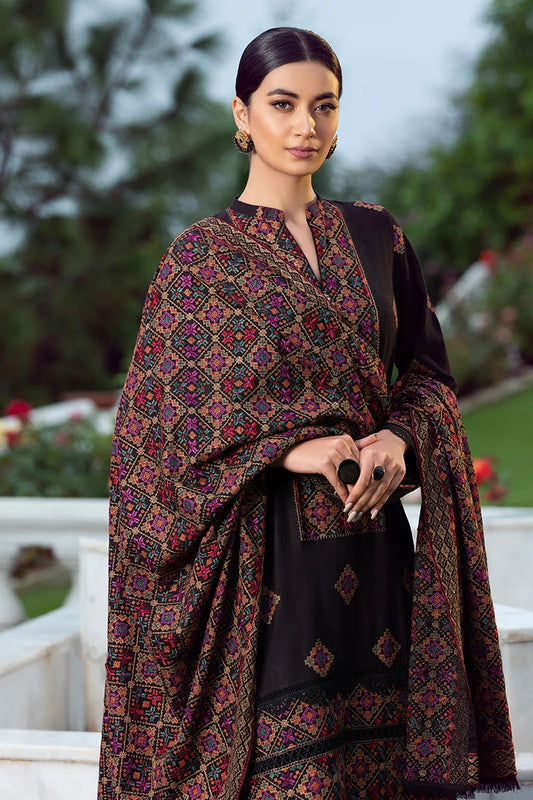 Woman wearing a black outfit with a patterned shawl outdoors