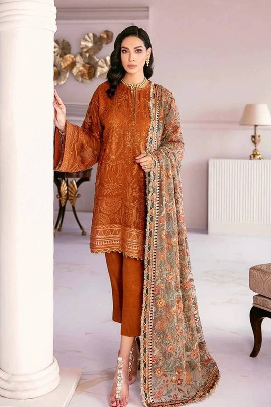 Woman wearing a traditional outfit with a long embroidered scarf in a room setting.