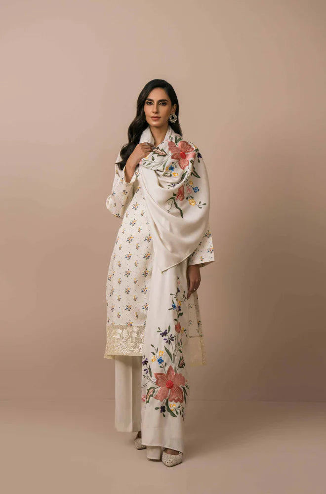 Woman wearing a white embroidered outfit against a beige background