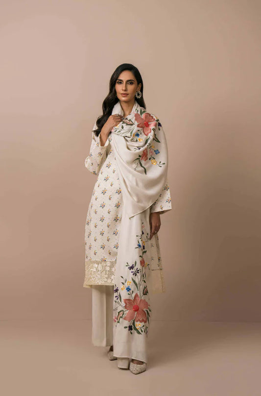 Woman wearing a white embroidered outfit against a beige background