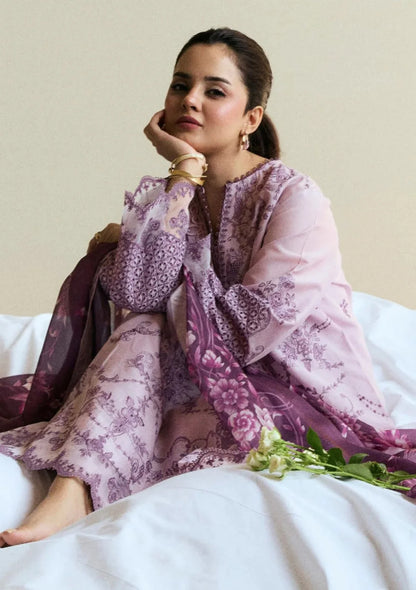 Woman wearing a pink and purple floral dress with a white background