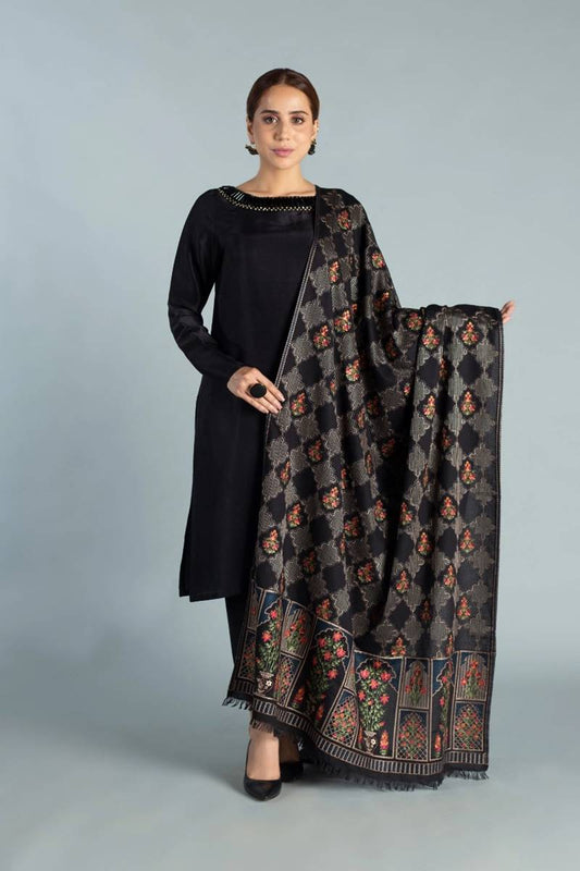 Woman holding a black patterned scarf against a gray background